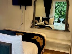 a mirror in a bedroom with a bed and a mirror at Pass the Keys Cosy one bed flat with parking and scenic views in Rickmansworth