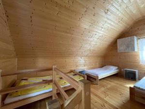DebrznoにあるWypoczynek Hnatczakの木造キャビン内の二段ベッド2台が備わる客室です。