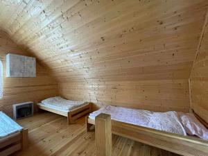 um quarto com 2 camas num chalé de madeira em Wypoczynek Hnatczak em Debrzno