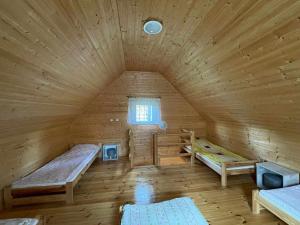 DebrznoにあるWypoczynek Hnatczakのベッド2台と窓が備わる広い木造の客室です。