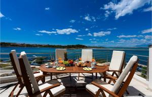 einen Esstisch auf einem Balkon mit Blick auf das Wasser in der Unterkunft Villa A&M 2 in Nin