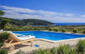 a swimming pool with a lounge chair next to the ocean at Villa Mar in Lumbarda