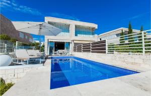 a swimming pool in front of a house at Villa Lantana in Petrcane