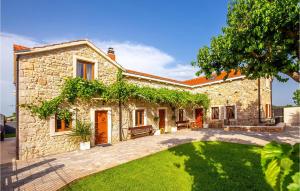 a stone house with a lawn in front of it at Villa Ambar in Škabrnje