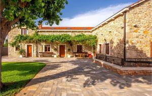 an exterior view of a stone house with a patio at Villa Ambar in Škabrnje