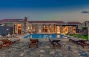 a swimming pool in front of a stone building with chairs at Villa Ambar in Škabrnje +32 photos