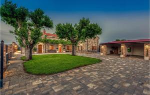 a stone house with trees in the yard at Villa Ambar in Škabrnje