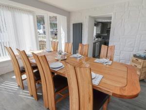 a wooden dining room table with wooden chairs and a table at Ffriddoedd in Llanfairfechan