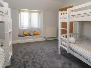 a room with two bunk beds and two windows at Ffriddoedd in Llanfairfechan