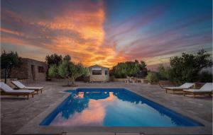 ポヴィヤにあるVilla Marioの椅子のあるプールと背景に夕日