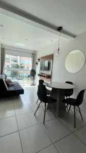 ein Wohnzimmer mit Tisch und Stühlen in der Unterkunft Muro Alto Condomínio Clube Apto 219 in Ipojuca