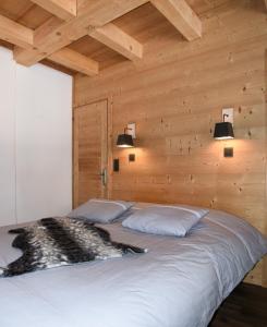 a large bed in a wooden room with two lamps at Chalet Loan in Montgenèvre