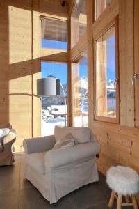 a living room with a white couch in a room with windows at Chalet Loan in Montgenèvre