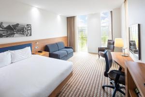 a hotel room with a bed and a desk and chair at Hampton By Hilton Amsterdam Arena Boulevard in Amsterdam