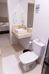 Łazienka z białą toaletą i umywalką w obiekcie Pôr do Sol Hotel w mieście Santarém