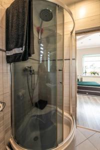 a shower with a glass door in a bathroom at Domek Gościnny Czempion in Strzałkowo