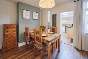 a dining room with a wooden table and chairs at Host & Stay - Church View Cottage in Matlock