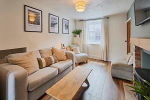a living room with a couch and a fireplace at Church View Cottage & Secret Garden, Matlock - Now Hosted by StayHostSave in Matlock