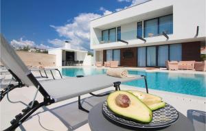 a table with a plate of avocado on a table next to a pool at Villa Korina in Primošten