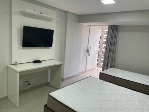 a white bedroom with a bed and a television at GARVEY PARK in Brasilia +11 photos