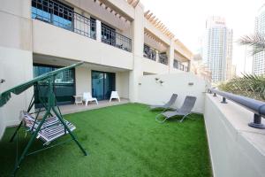 a yard with a swing and chairs in a building at Entire rental unit hosted by ECO PRIME HOMES in Dubai