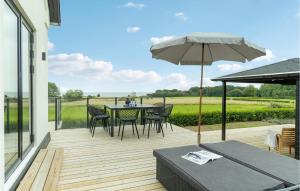 a patio with a table and chairs and an umbrella at Amazing Home In Tranekr With Wifi in Tranekær