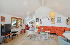un soggiorno con divano arancione e TV di Cozy Home In Nykbing Sj With Kitchen a Nykøbing Sjælland
