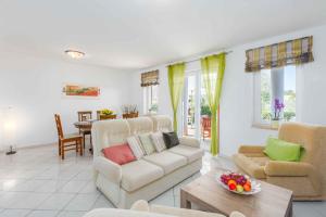 ein Wohnzimmer mit einem Sofa, Stühlen und einem Tisch in der Unterkunft Holiday home in Porec/Istrien 10097 in Poreč