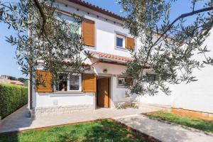 ein weißes Haus mit orangefarbenen Fensterläden darauf in der Unterkunft Holiday home in Porec/Istrien 10097 in Poreč