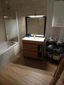 a bathroom with a sink and a mirror and a tub at La Belle Armentières, maison triplex cosy proche de Lille in Armentières