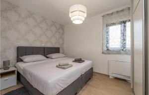 Un dormitorio con una cama grande con sábanas blancas. en Villa Nika, en Zadar