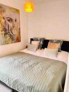 een slaapkamer met een bed met een schilderij aan de muur bij Heerlijk appartement Centrum Breda en restaurant! in Breda