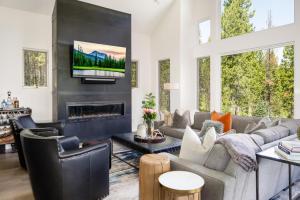 a living room with a couch and a fireplace at Gray Owl Retreat in Big Sky