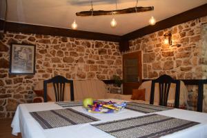 ein Esszimmer mit einem Tisch und einer Schüssel Essen darauf in der Unterkunft Kamena Oaza in Stolac