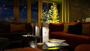 ヴァル・ディゼールにあるHotel MONT-BLANC VAL D'ISEREのリビングルーム(テーブル、クリスマスツリー付)