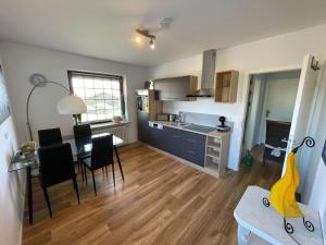 a kitchen with a table and chairs in a room at Fewo Zum Wohlfühlen in Hemmoor