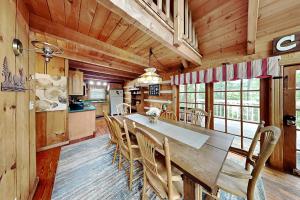 a dining room and kitchen with a wooden table and chairs at Bear Cave Haus, 2 Bedrooms, Fireplace, Hot Tub, Pool Table, WiFi, Sleeps 8 in Gatlinburg