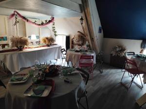 una habitación con dos mesas con manteles blancos en Hôtellerie Jardiniers Gourmands en Morsains