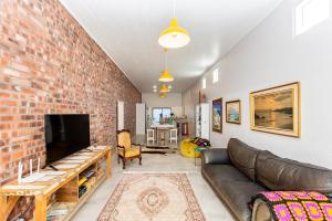 a living room with a couch and a brick wall at Dunes, Waves and Shells Self Catering Units and The Beach Shack Caravan Langebaan in Langebaan
