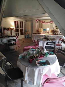 una habitación con dos mesas con manteles blancos en Hôtellerie Jardiniers Gourmands en Morsains