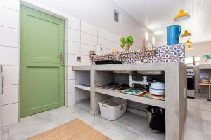 a kitchen with a green door in a room at Dunes, Waves and Shells Self Catering Units and The Beach Shack Caravan Langebaan in Langebaan