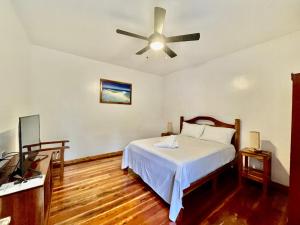 1 dormitorio con 1 cama y ventilador de techo en Agoho Resort en Mambajao