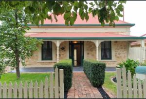 a white picket fence in front of a house at Close to CBD Renovated Cottage in Prospect
