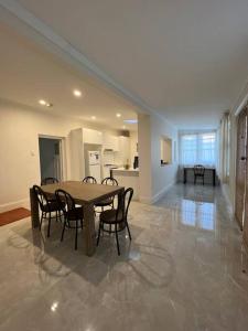 a dining room with a table and chairs and a kitchen at Close to CBD Renovated Cottage in Prospect