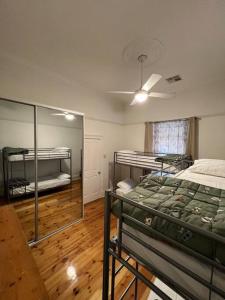 a bedroom with two bunk beds and a mirror at Close to CBD Renovated Cottage in Prospect