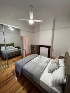 a bedroom with a large bed and a mirror at Close to CBD Renovated Cottage in Prospect