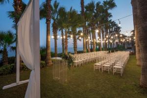 um corredor com cadeiras e palmeiras num casamento em Mersin HiltonSA em Mersin