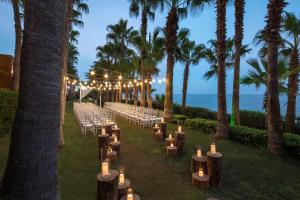 Un pasillo de bodas con velas y palmeras en Mersin HiltonSA, en Mersin