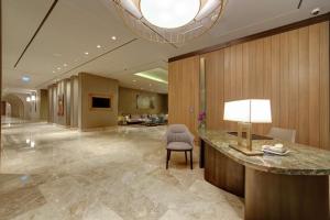 a hotel lobby with a desk and a chair at Mersin HiltonSA in Mersin