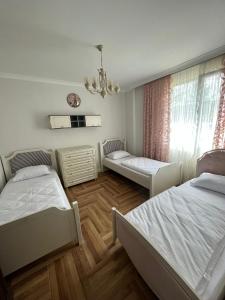 um quarto com 2 camas e um lustre em Bahçeli villa dairesi em Trabzon